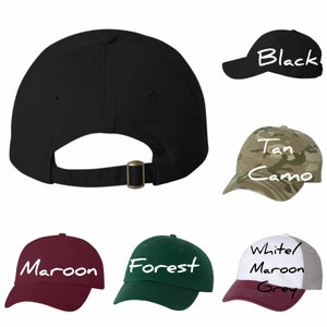May include: Assortment of baseball caps in various colors and patterns, including black, tan camo, maroon, forest green, white/maroon grey.  The caps feature a classic design with a curved brim and adjustable strap.