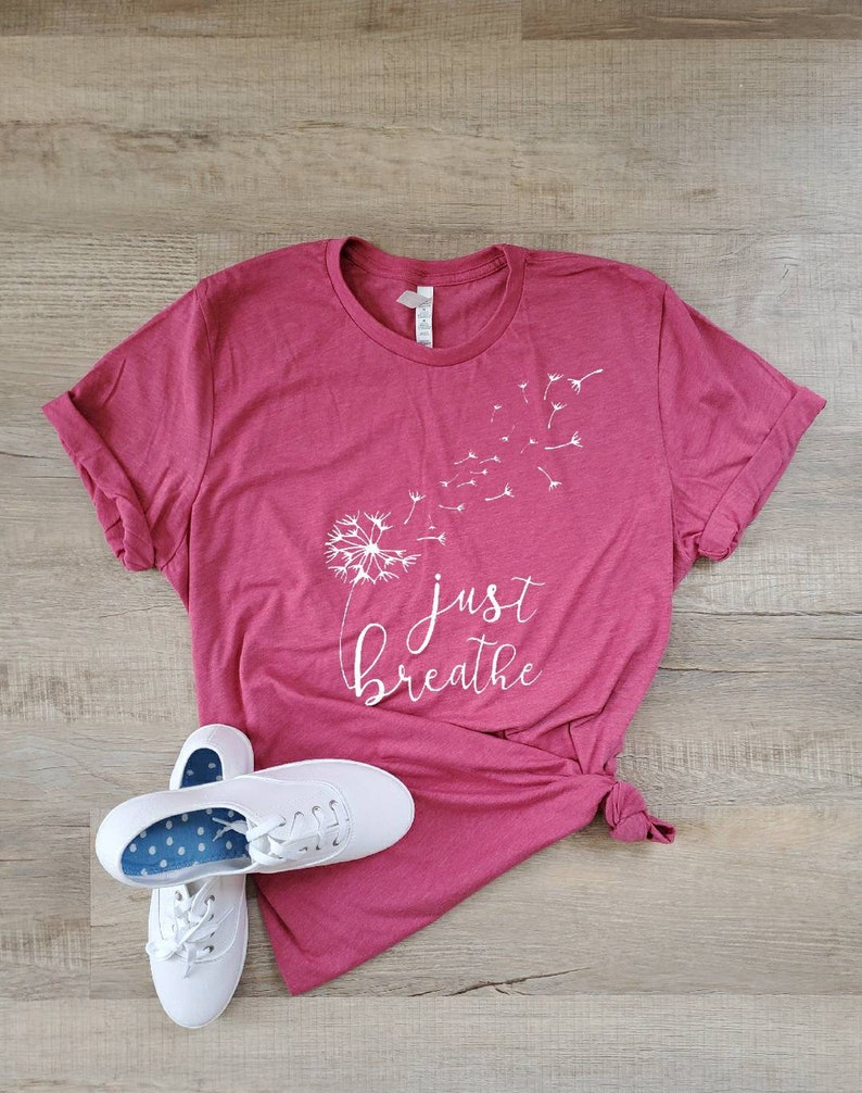 May include: A maroon t-shirt with a white dandelion graphic and the text "just breathe".