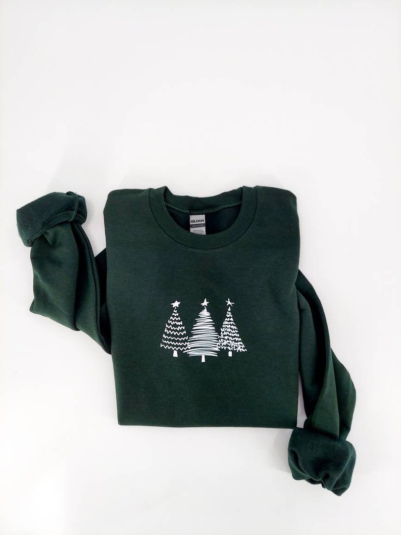 May include: A dark green sweatshirt with a white design of three stylized Christmas trees.