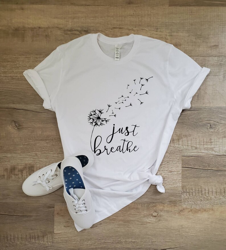 May include: White t-shirt with a black dandelion graphic and the text "just breathe".