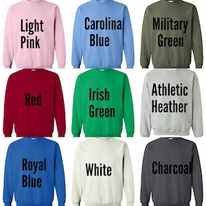 May include: Nine different color sweatshirts with text on the front. The colors are light pink, Carolina blue, military green, red, Irish green, athletic heather, royal blue, white, and charcoal.
