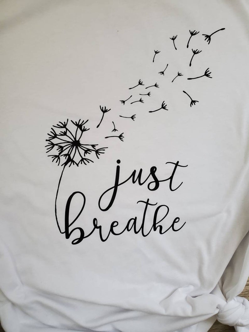 May include: White t-shirt with a black dandelion design and the text "just breathe" printed on it.