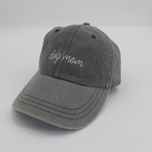 Puede incluir: Una gorra de b&eacute;isbol gris con el texto "dog mom" bordado en blanco en la parte delantera.