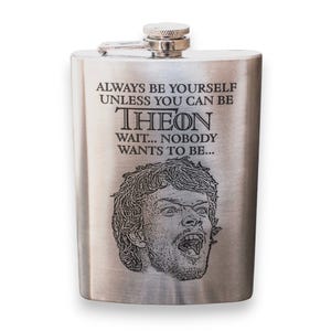 May include: A silver flask with an engraved image of a man's face and the text "ALWAYS BE YOURSELF UNLESS YOU CAN BE THEON WAIT... NOBODY WANTS TO BE..."