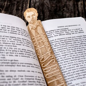 Könnte beinhalten: Ein Holz-Lesezeichen mit einem Porträt eines Mannes mit Krawatte. Das Lesezeichen ist mit dem Text "How Was I Supposed To Know?" graviert.