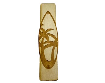 May include: A wooden surfboard ornament with a cutout design of palm trees. The ornament is light brown and has a hole at the top for hanging.