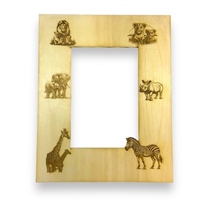 May include: A wooden picture frame with a light brown finish. The frame has a cutout for a photo and is decorated with laser-engraved images of various African animals, including a zebra, giraffe, rhino, lion, and elephants.