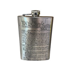 Puede incluir: Una petaca de plata con el texto "We the People" y el primer artículo de la Constitución de los Estados Unidos impreso en la parte delantera.