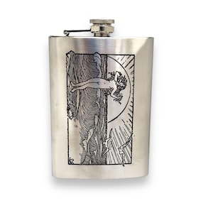 Puede incluir: Una petaca de plata con una imagen grabada de una mujer de pie en las olas del océano con el sol saliendo detrás de ella.