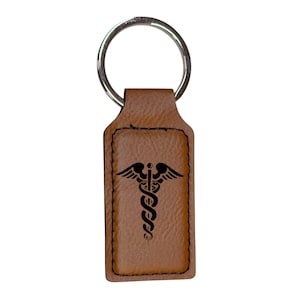 May include: A brown leather keychain with a silver key ring and a black medical symbol engraved on the front.