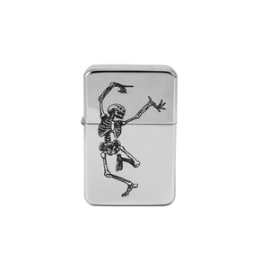 May include: A silver lighter with a black skeleton design. The skeleton is dancing with its arms raised.