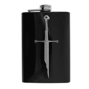 May include: Black stainless steel flask with a silver sword design. The sword is a stylized version of a fantasy sword.