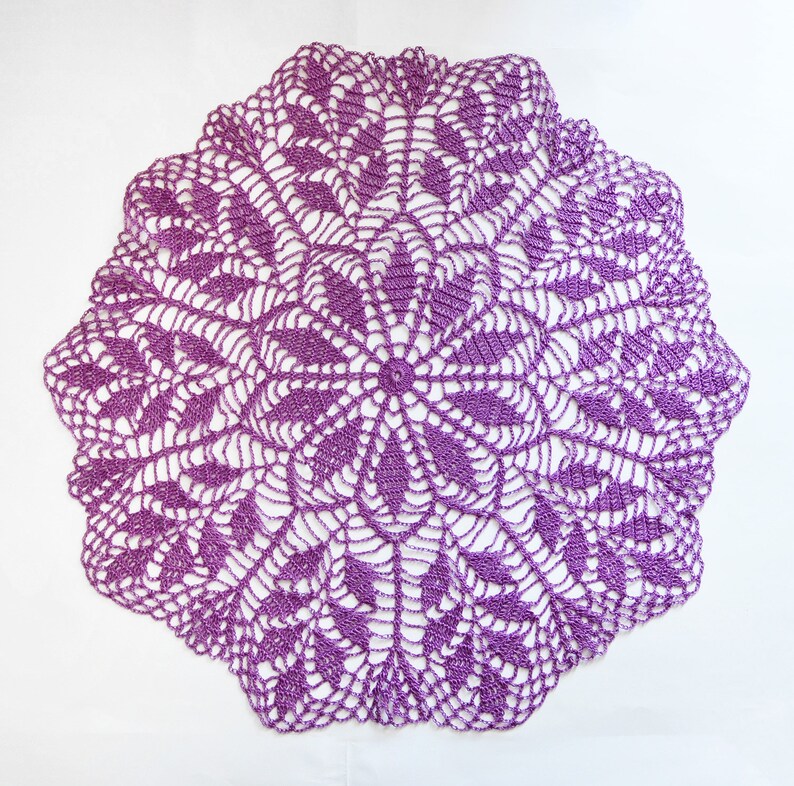 Puede incluir: Un encaje de ganchillo morado con un delicado patr&oacute;n floral.