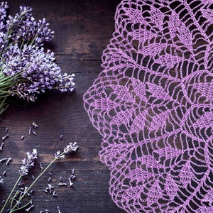 Puede incluir: Un encaje de ganchillo morado con un delicado patr&oacute;n floral, sobre un fondo de madera r&uacute;stica con ramitas de lavanda.