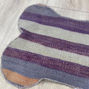 Handmade colorful Turkish Kilim pet mats, boho upcycled rug designed for pets, unique bone-shaped feeding mat, durable woven fabric, eco-friendly recycled carpet, decorative home accent, vibrant patterns and textures, comfortable and easy-to-clean, perfect for indoor or outdoor use, adds charm to any pet feeding area, ideal gift for pet lovers, artisanal inspired Turkish weave, stylish addition to pet space, one-of-a-kind handmade design.