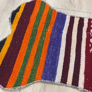 Handmade colorful Turkish Kilim pet mats, boho upcycled rug designed for pets, unique bone-shaped feeding mat, durable woven fabric, eco-friendly recycled carpet, decorative home accent, vibrant patterns and textures, comfortable and easy-to-clean, perfect for indoor or outdoor use, adds charm to any pet feeding area, ideal gift for pet lovers, artisanal inspired Turkish weave, stylish addition to pet space, one-of-a-kind handmade design.
