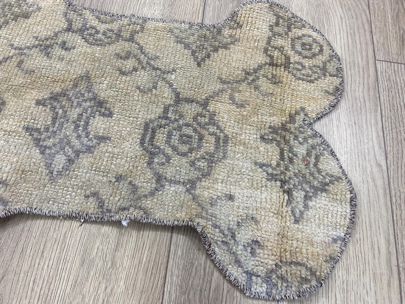 Handmade colorful Turkish Kilim pet mats, boho upcycled rug designed for pets, unique bone-shaped feeding mat, durable woven fabric, eco-friendly recycled carpet, decorative home accent, vibrant patterns and textures, comfortable and easy-to-clean, perfect for indoor or outdoor use, adds charm to any pet feeding area, ideal gift for pet lovers, artisanal inspired Turkish weave, stylish addition to pet space, one-of-a-kind handmade design.