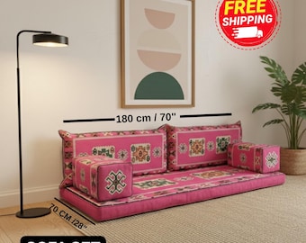 May include: A floor sofa set featuring a long pink cushion with a multi-colored geometric pattern, two matching backrest cushions, and two armrest cushions. The set measures 180 inches in length and 28 inches in width as indicated by labels.