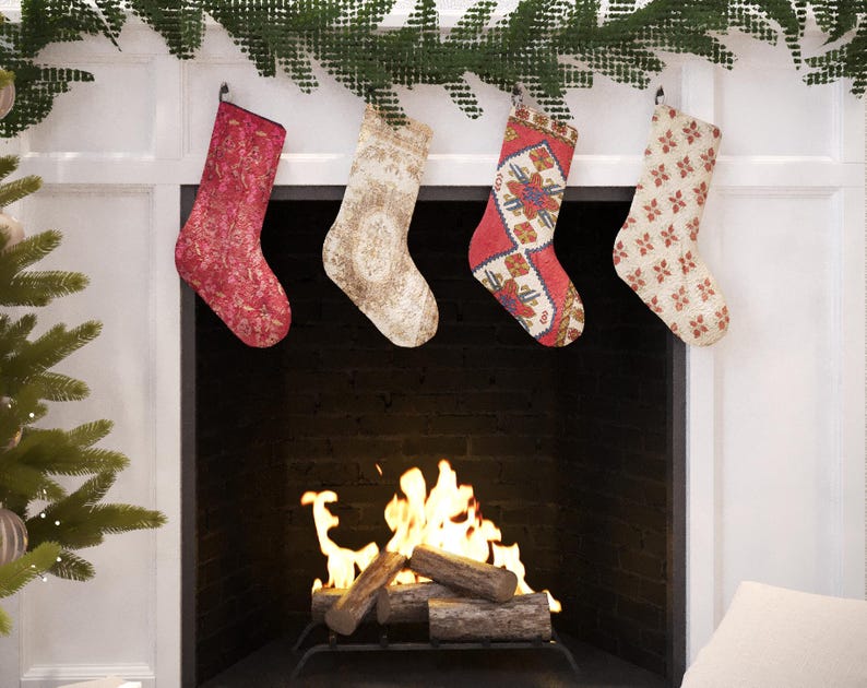 Set of 4 handmade vintage-style Christmas stockings, including red, beige floral, and a traditional red and blue Turkish kilim print, hanging on a fireplace mantel.