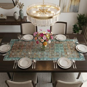 a dining room with a large wooden table set for four, featuring white plates, silverware, and a vase of colorful flowers. The table is surrounded by four chairs, and a chandelier hangs above it, casting a warm glow over the scene. The room is decorated with various vases, potted plants, and other decorative elements, creating a cozy and inviting atmosphere.