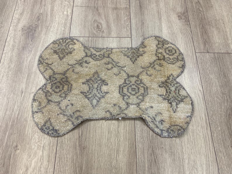 Handmade colorful Turkish Kilim pet mats, boho upcycled rug designed for pets, unique bone-shaped feeding mat, durable woven fabric, eco-friendly recycled carpet, decorative home accent, vibrant patterns and textures, comfortable and easy-to-clean, perfect for indoor or outdoor use, adds charm to any pet feeding area, ideal gift for pet lovers, artisanal inspired Turkish weave, stylish addition to pet space, one-of-a-kind handmade design.