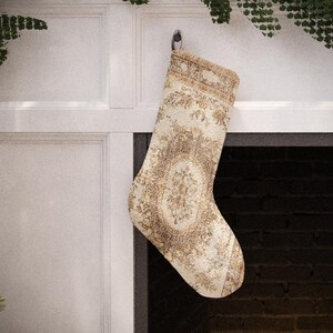 Set of 4 handmade vintage-style Christmas stockings, including red, beige floral, and a traditional red and blue Turkish kilim print, hanging on a fireplace mantel.