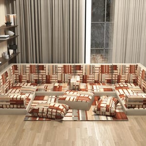 Könnte beinhalten: Ein U-förmiges Ecksofa mit einem geometrischen Muster in Braun, Beige und Rot. Das Sofa umfasst passende Kissen und einen Teppich. Der Raum hat Holzböden und neutrale Vorhänge. Das Sofa ist ein Blickfang.