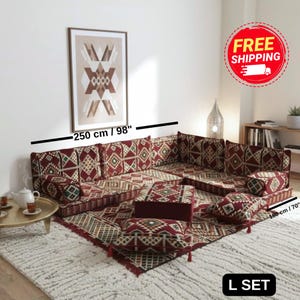 Peut inclure: Un ensemble de canapé en forme de L avec un motif bordeaux, vert et crème. L'ensemble comprend des coussins, un tapis et un pouf assorti. Le canapé mesure 250 cm de long et 180 cm de large. L'ensemble est étiqueté "L SET".