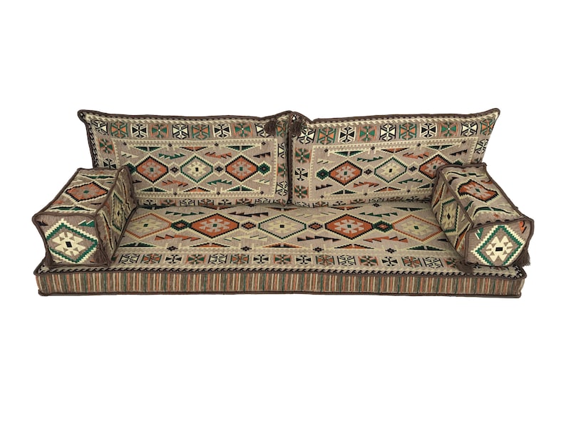 May include: A brown and beige floor cushion with a geometric pattern. The cushion is made up of three sections, two backrests and a main seating area. The cushion is perfect for sitting on the floor.