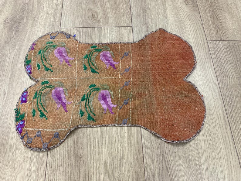 Handmade colorful Turkish Kilim pet mats, boho upcycled rug designed for pets, unique bone-shaped feeding mat, durable woven fabric, eco-friendly recycled carpet, decorative home accent, vibrant patterns and textures, comfortable and easy-to-clean, perfect for indoor or outdoor use, adds charm to any pet feeding area, ideal gift for pet lovers, artisanal inspired Turkish weave, stylish addition to pet space, one-of-a-kind handmade design.