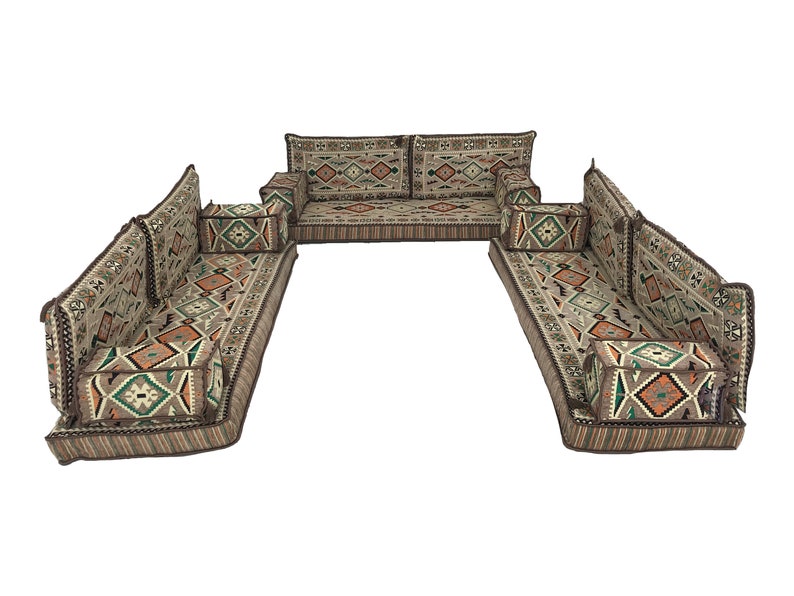 May include: A traditional floor seating set with a U-shaped configuration. The set features a large, rectangular center piece and two smaller, rectangular side pieces. The cushions are covered in a beige fabric with a geometric pattern in shades of brown, orange, and green.
