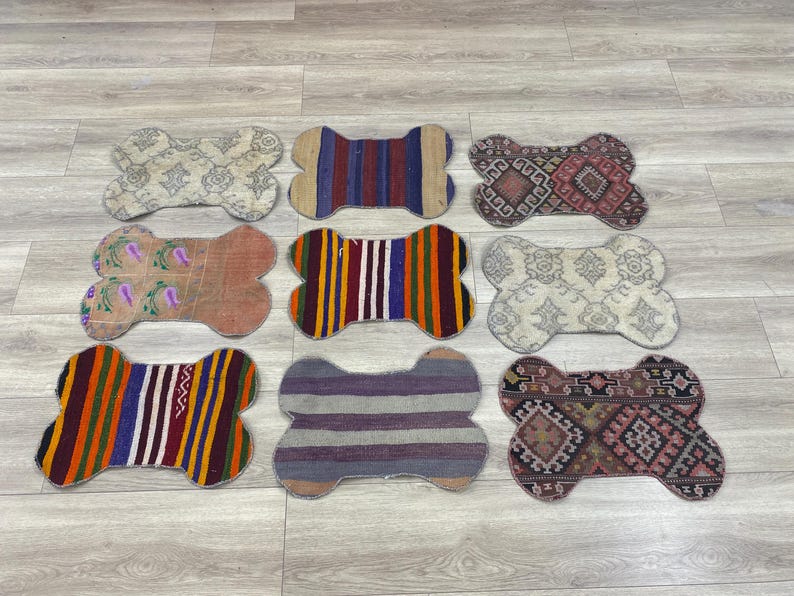 Handmade colorful Turkish Kilim pet mats, boho upcycled rug designed for pets, unique bone-shaped feeding mat, durable woven fabric, eco-friendly recycled carpet, decorative home accent, vibrant patterns and textures, comfortable and easy-to-clean, perfect for indoor or outdoor use, adds charm to any pet feeding area, ideal gift for pet lovers, artisanal inspired Turkish weave, stylish addition to pet space, one-of-a-kind handmade design.