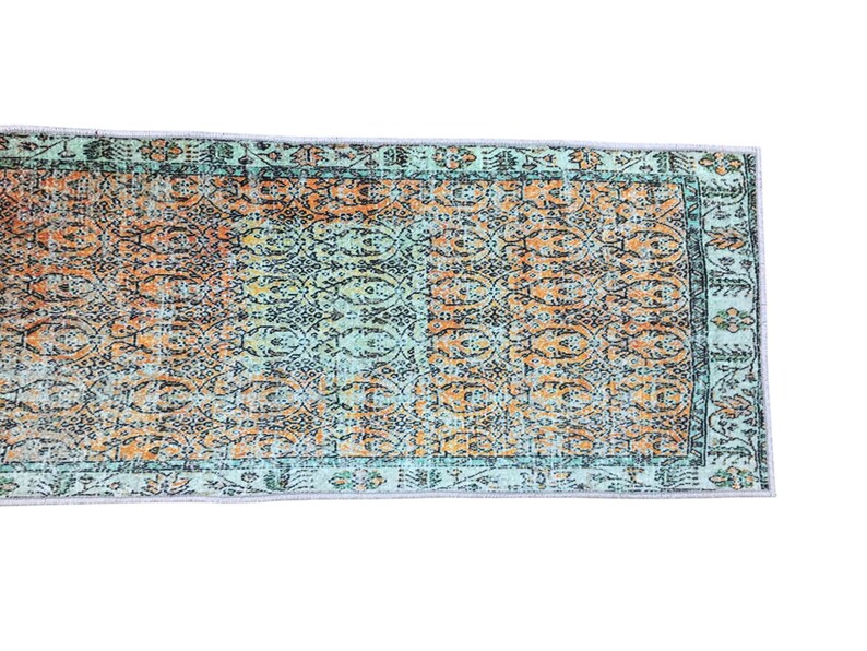 a colorful, patterned rug with a geometric design in shades of blue, orange, and green.