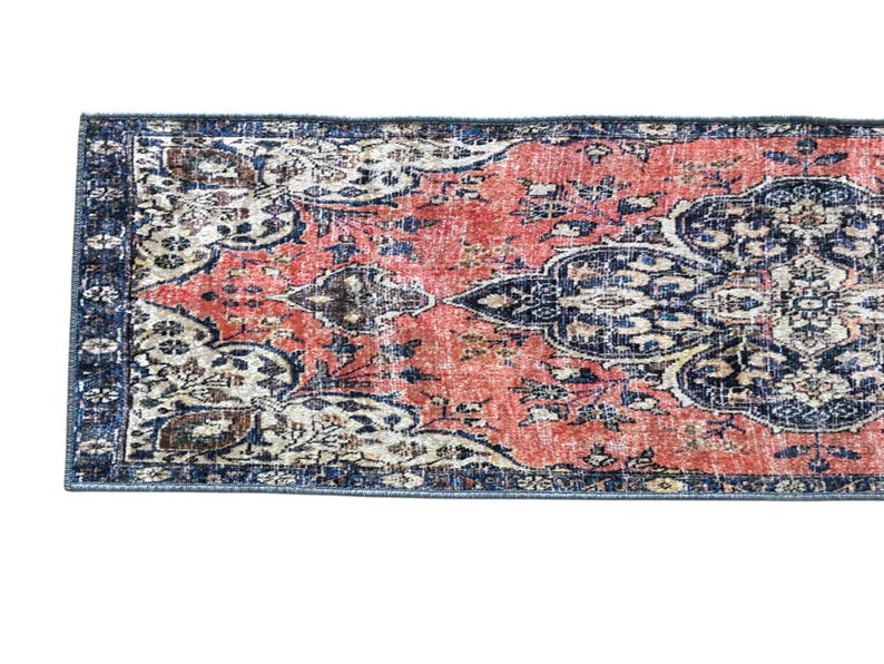 a vibrant, intricately patterned rug with a mix of red, blue, and white colors. The rug has a detailed design with floral and geometric patterns, creating a visually striking and eye-catching piece.