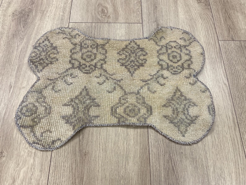Handmade colorful Turkish Kilim pet mats, boho upcycled rug designed for pets, unique bone-shaped feeding mat, durable woven fabric, eco-friendly recycled carpet, decorative home accent, vibrant patterns and textures, comfortable and easy-to-clean, perfect for indoor or outdoor use, adds charm to any pet feeding area, ideal gift for pet lovers, artisanal inspired Turkish weave, stylish addition to pet space, one-of-a-kind handmade design.