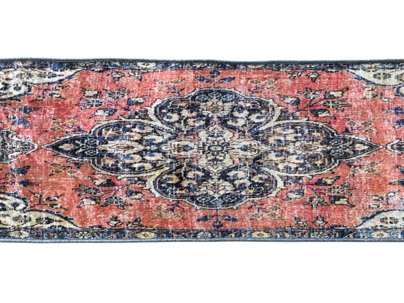 a vibrant, intricately patterned rug with a striking combination of red, blue, and white colors. The rug is adorned with a floral design and appears to be a piece of traditional or cultural art.