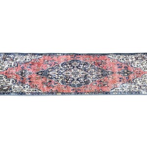 a large, rectangular rug with a floral pattern in shades of red, blue, and white.