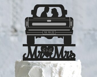 May include: Black silhouette of a pickup truck with a couple inside, a heart with the initials "S & A" and the words "Mr & Mrs" on a white cake.