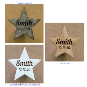 May include: Wooden star ornaments in brown, rose, and polished white. Each star features the name "Smith" and the date "12.12.20" engraved in a contrasting color. The ornaments are ideal for personalized gifts or holiday decorations.