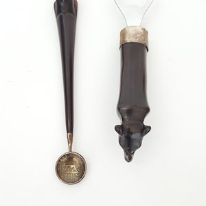 East African carved ebony rhinoceros on bottle opener and shilling spoon-Lot of 2