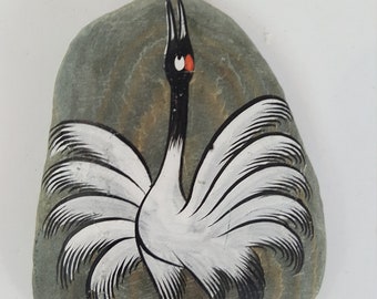 hand painted rock paperweight of bird in black, white, and red