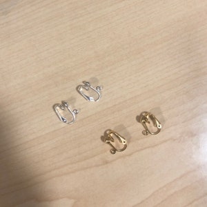 May include: Two pairs of earring clips, one pair is silver and the other is gold.