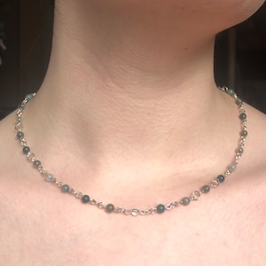 Peut inclure: Un collier en chaîne argent avec des perles d'agate vertes et grises.