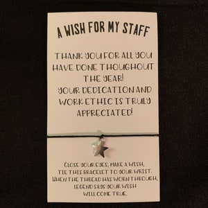 May include: A white card with black text that reads "A Wish for My Staff" and "Thank you for all you have done throughout the year! Your dedication and work ethic is truly appreciated!"  The card also has a silver star charm attached to a black string.