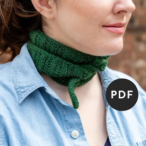 May include: A green crocheted neck warmer with a long tail. The neck warmer is folded over and worn around the neck. The image has a PDF label.