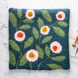 May include: A teal blue hand-stitched rug with a floral design. The rug features pink, orange, and yellow flowers with green leaves.