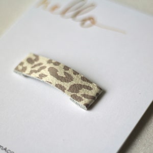 Puede incluir: Un peque&ntilde;o clip para el pelo de estampado de leopardo beige y marr&oacute;n.