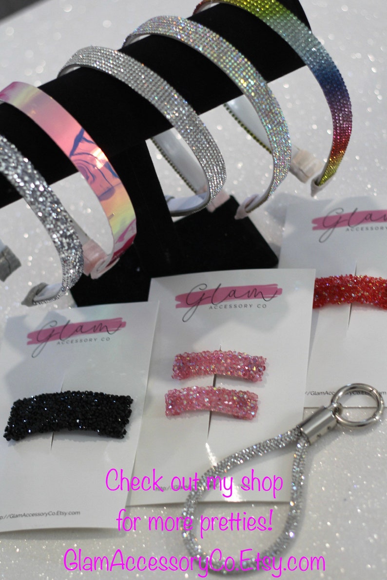 Puede incluir: Surtido de accesorios para el cabello brillantes, que incluyen diademas, pinzas y un llavero. Las diademas son plateadas, iridiscentes y de colores arco&iacute;ris. Las pinzas son negras y rosas. El llavero es plateado con un cord&oacute;n brillante. Los productos se muestran sobre un fondo blanco con el texto "Glam Accessory Co."