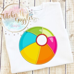 May include: A colorful beach ball with yellow, orange, green, blue, and pink sections. The ball has a white circle in the center.