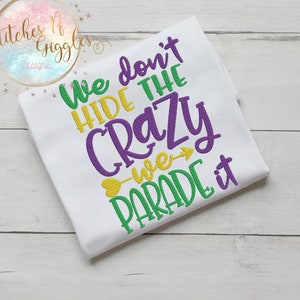 Puede incluir: Camiseta blanca con bordado morado y verde que dice "We don't hide the crazy we parade it".